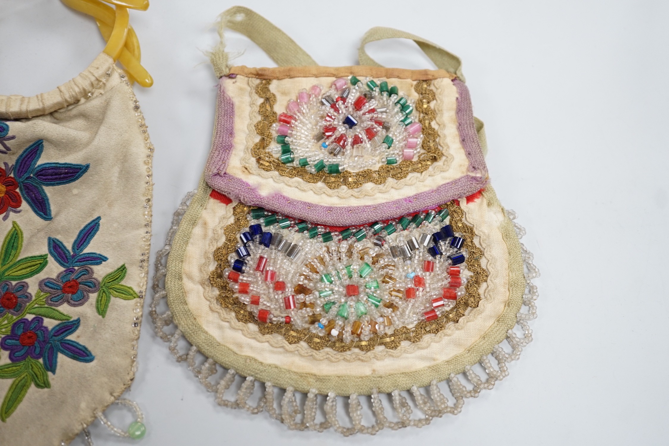 A mid to late 19th century Iroquois, North American/Canadian Indian glass beadwork bag on linen, together with a smaller red wool beaded purse and a 20th century suede embroidered bag with beaded fringe